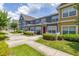 View of the townhome with colorful facades, white picket fences, and landscaped greenery at 2620 Lodi Cir # 103, Kissimmee, FL 34746