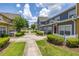 View of the townhome with colorful facades, white picket fences, and landscaped greenery at 2620 Lodi Cir # 103, Kissimmee, FL 34746