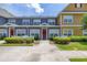 Charming townhome exterior featuring colorful facades, white picket fences, and landscaped greenery under a sunny sky at 2620 Lodi Cir # 103, Kissimmee, FL 34746