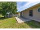 Backyard features a concrete patio and mature trees, perfect for outdoor relaxation and entertainment at 265 Curtis Ave, Groveland, FL 34736