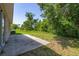 Backyard features a concrete patio, lush greenery, and an AC unit at 265 Curtis Ave, Groveland, FL 34736