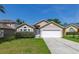Charming single-story home with a well-manicured lawn, two-car garage, and inviting entryway at 265 Curtis Ave, Groveland, FL 34736