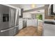 Well-lit kitchen features stainless steel appliances, tile flooring, and bright white cabinetry at 265 Curtis Ave, Groveland, FL 34736