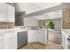 Bright kitchen featuring white cabinets, stainless steel appliances, and mosaic backsplash at 265 Curtis Ave, Groveland, FL 34736