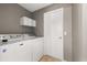 Functional laundry room featuring a washer, dryer, and built-in shelves, offering convenience and organization at 265 Curtis Ave, Groveland, FL 34736