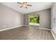 Bright living room featuring vinyl plank flooring, a ceiling fan, and a sliding door at 265 Curtis Ave, Groveland, FL 34736