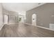 Open-concept living room with arched doorways and wood-look floors at 265 Curtis Ave, Groveland, FL 34736