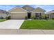 Charming single-Gathering home with manicured lawn, inviting front entrance, and attached two-car garage at 2715 Barclay Ln, Kissimmee, FL 34743