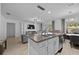Modern kitchen island with sink, granite countertops, and bar seating; open to the living and dining areas at 2715 Barclay Ln, Kissimmee, FL 34743