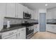 Contemporary kitchen with white cabinets, stainless steel appliances, granite countertops, and tile backsplash at 2715 Barclay Ln, Kissimmee, FL 34743