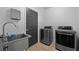 Efficient laundry room featuring a stainless steel sink, modern washer and dryer at 2715 Barclay Ln, Kissimmee, FL 34743