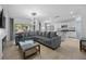 Open-concept living space with modern lighting, comfortable sectional sofa, and seamless flow to the kitchen at 2715 Barclay Ln, Kissimmee, FL 34743