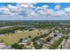 Wide aerial shot capturing a residential neighborhood with lush green spaces and scattered trees on a sunny day at 3125 Samosa Hill Cir, Clermont, FL 34714