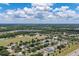 Wide aerial shot capturing a residential neighborhood with lush green spaces and scattered trees on a sunny day at 3125 Samosa Hill Cir, Clermont, FL 34714