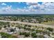 Real estate aerial view showing a community near a highway, surrounded by trees and foliage at 3125 Samosa Hill Cir, Clermont, FL 34714