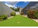 Backyard putting green with well-maintained landscaping and a partial view of the home's exterior at 3125 Samosa Hill Cir, Clermont, FL 34714