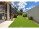 Manicured backyard featuring a putting green, lush landscaping, and privacy fence, perfect for outdoor activities at 3125 Samosa Hill Cir, Clermont, FL 34714