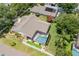 Aerial view of a backyard featuring screened pool, putting green, surrounded by lush greenery and landscaping at 3125 Samosa Hill Cir, Clermont, FL 34714