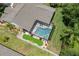 Aerial view of a backyard featuring screened pool, putting green, surrounded by lush greenery at 3125 Samosa Hill Cir, Clermont, FL 34714