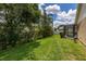 Expansive backyard with lush greenery, mature trees, and partial view of the screened-in patio and the pool at 3125 Samosa Hill Cir, Clermont, FL 34714