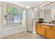 Bright bathroom featuring a soaking tub, shower, and vanity with wood cabinets at 3125 Samosa Hill Cir, Clermont, FL 34714