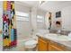 Inviting bathroom featuring a shower/tub, window, and colorful Mickey Mouse shower curtain at 3125 Samosa Hill Cir, Clermont, FL 34714