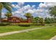 Brick 'Orange Tree' community sign surrounded by palm trees and lush green landscaping at 3125 Samosa Hill Cir, Clermont, FL 34714