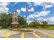 Inviting community entrance featuring a brick tower, American flag, lush landscaping and an 'Orange Tree' brick sign at 3125 Samosa Hill Cir, Clermont, FL 34714