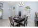 Formal dining room with vaulted ceilings, modern chandelier, and decorative accents create an inviting atmosphere at 3125 Samosa Hill Cir, Clermont, FL 34714