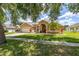 Beautiful residence with a manicured lawn, mature trees, and a welcoming entrance at 3125 Samosa Hill Cir, Clermont, FL 34714