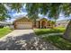 Attractive home with a well-maintained lawn, spacious driveway, and lush landscaping at 3125 Samosa Hill Cir, Clermont, FL 34714