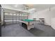 Finished garage featuring a billiard table, seating, and garage door with windows at 3125 Samosa Hill Cir, Clermont, FL 34714
