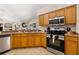 Kitchen featuring stainless steel appliances, breakfast bar and wood cabinets at 3125 Samosa Hill Cir, Clermont, FL 34714