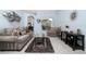 Spacious living room with a plush sofa, accent chair, glass coffee table and stylish decor at 3125 Samosa Hill Cir, Clermont, FL 34714