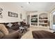 Comfortable living room with brown sectional, tile floors, and decorative shelving at 3125 Samosa Hill Cir, Clermont, FL 34714