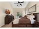Comfortable main bedroom with a dark wood bed, ceiling fan, TV, and ample natural light creating a relaxing retreat at 3125 Samosa Hill Cir, Clermont, FL 34714