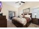 Cozy main bedroom featuring a dark wood bed frame, ample natural light, and a view of the outdoor area at 3125 Samosa Hill Cir, Clermont, FL 34714