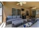 Comfortable covered patio area with plush seating, TV, and grill for outdoor entertaining at 3125 Samosa Hill Cir, Clermont, FL 34714
