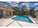 Screened-in pool with a spa, lounge chairs and lush landscaping at 3125 Samosa Hill Cir, Clermont, FL 34714