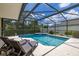Relaxing screened-in pool and spa surrounded by lush landscaping and comfortable lounge chairs at 3125 Samosa Hill Cir, Clermont, FL 34714