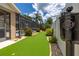 Backyard putting green with manicured landscaping and view of screened pool enclosure at 3125 Samosa Hill Cir, Clermont, FL 34714