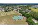 Wide aerial shot showcasing tennis and pickleball courts, with nearby homes and tree-lined streets at 3125 Samosa Hill Cir, Clermont, FL 34714