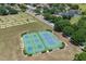 Aerial view of tennis and pickleball courts, lush green landscaping and single Gathering homes at 3125 Samosa Hill Cir, Clermont, FL 34714