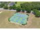 Aerial view of a well-maintained tennis and pickleball courts surrounded by green landscaping and nearby homes at 3125 Samosa Hill Cir, Clermont, FL 34714