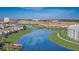 Aerial view of neighborhood, golf course, and a lake with walking bridge at 3150 Paradox Cir # 104, Kissimmee, FL 34746