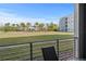 View from balcony shows a large lawn area with mature palm trees and condominium in the background at 3150 Paradox Cir # 104, Kissimmee, FL 34746