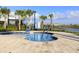 Community spa with clear water and disability lift surrounded by palm trees at 3150 Paradox Cir # 104, Kissimmee, FL 34746
