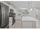 Modern kitchen open to the living area with large island and pendant lighting at 3150 Paradox Cir # 104, Kissimmee, FL 34746