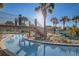 A picturesque view of the lazy river and bridge surrounded by lush landscaping and palms at 3150 Paradox Cir # 104, Kissimmee, FL 34746