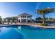 Community clubhouse with a pool surrounded by lounge chairs and palm trees at 3150 Paradox Cir # 104, Kissimmee, FL 34746